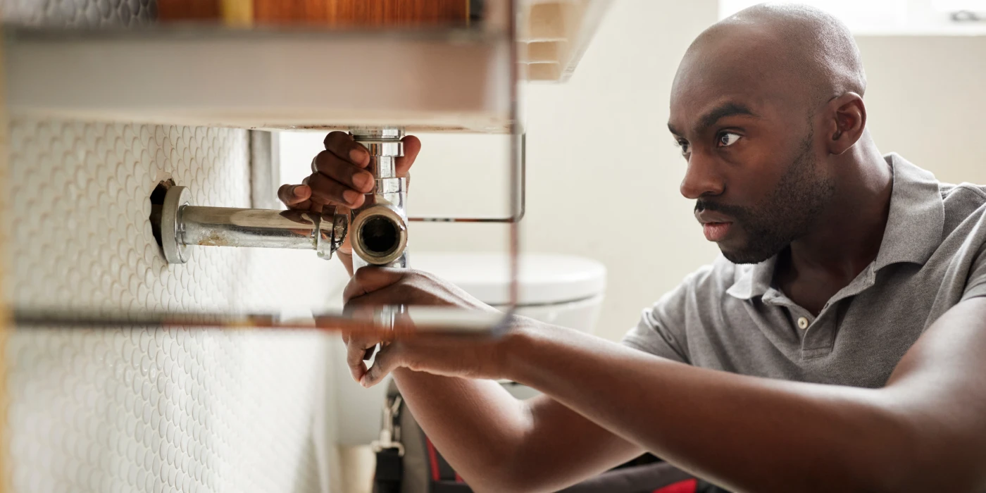 a male plumber fixing a pipe connection from The Cedar Park Plumber in Cedar Park, TX - Plumber near me
