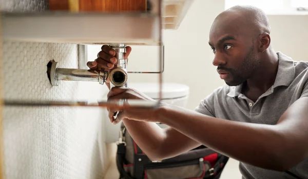 a male plumber fixing a pipe connection from The Cedar Park Plumber in Cedar Park, TX - Plumber near me