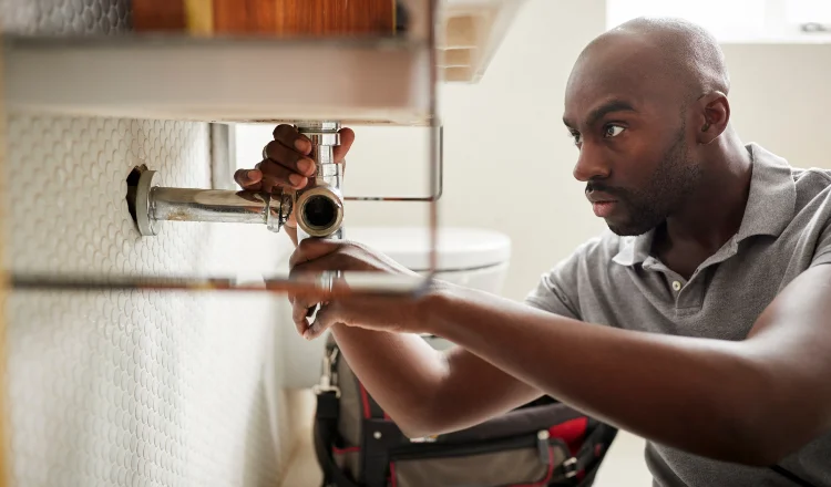 a male plumber fixing a pipe connection from The Cedar Park Plumber in Cedar Park, TX - Plumber near me